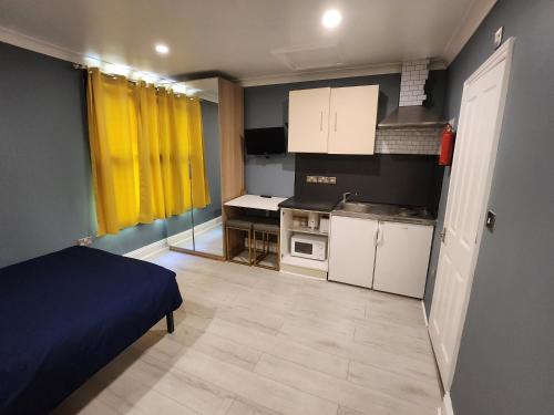 a small room with a bed and a kitchen at Dodi Apartment in London