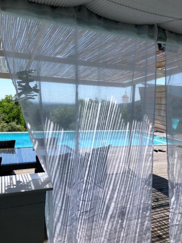 - une vue sur la piscine depuis une fenêtre transparente dans l'établissement Piscine Mer et Maquis, à San-Giuliano