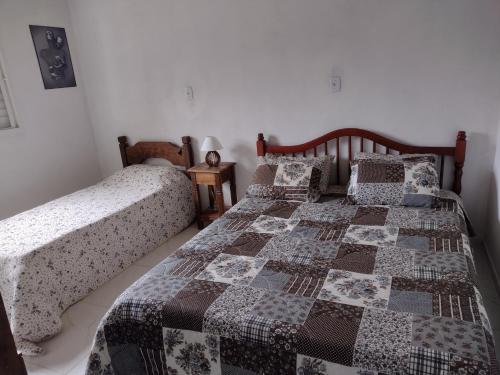 a bedroom with two twin beds with quilts at Chale 8A in Cunha