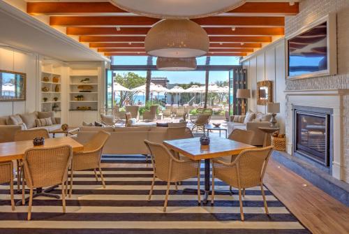a living room with tables and chairs and a fireplace at The Historic Cavalier Hotel and Beach Club Autograph Collection in Virginia Beach