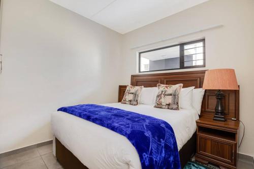 a bedroom with a large bed and a window at Grandeur by Mall of Africa in Midrand