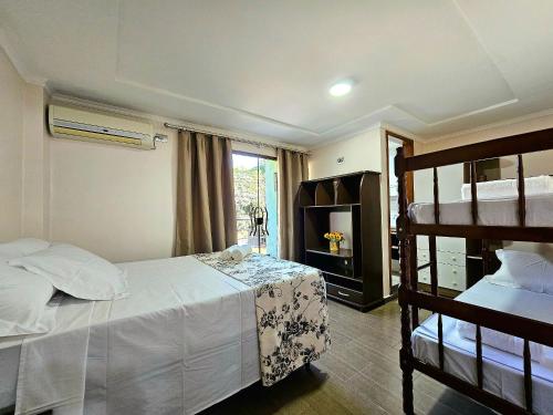 a bedroom with two bunk beds and a television at Apt Centro de Foz para até 8 pessoas in Foz do Iguaçu