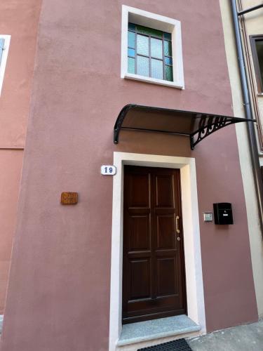 un edificio rosa con puerta y ventana en Il Vicolo en Revello