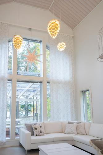 a living room with a white couch and a large window at Luxurious Villa Kinos with Jacuzzi in Rovaniemi