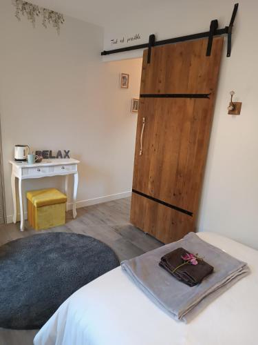 a bedroom with a sliding barn door and a table at Elise cornu in Mantry