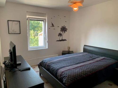 une chambre avec un lit, un bureau et une fenêtre dans l'établissement chambres chez Peggynette, à Taisnières-sur-Hon
