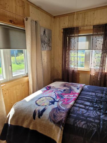 sypialnia z łóżkiem i dwoma oknami w obiekcie Le Gîte Du Gardien Blanc w mieście Saint-David-de-Falardeau