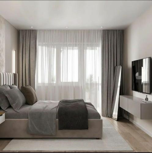 um quarto com uma cama e uma televisão em frente a uma janela em Korce Edea's 2 ApartHotel em Korçë