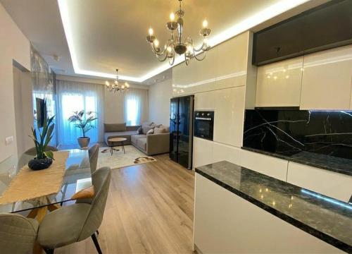 uma cozinha e sala de estar com uma mesa e um sofá em Korce Edea's 2 ApartHotel em Korçë