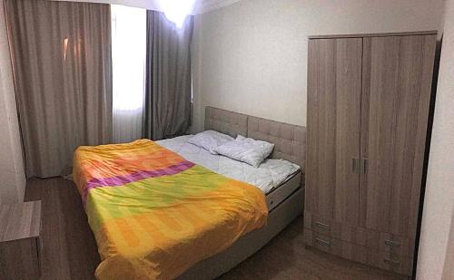 um quarto com uma cama com um cobertor colorido em Апартаменты для семьи (№4) em Yalova