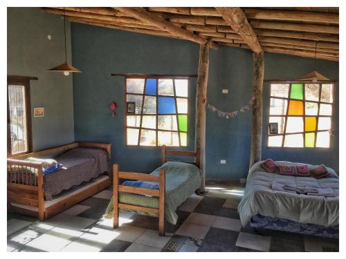 a bedroom with two beds and stained glass windows at Cabaña San Roque in Humahuaca