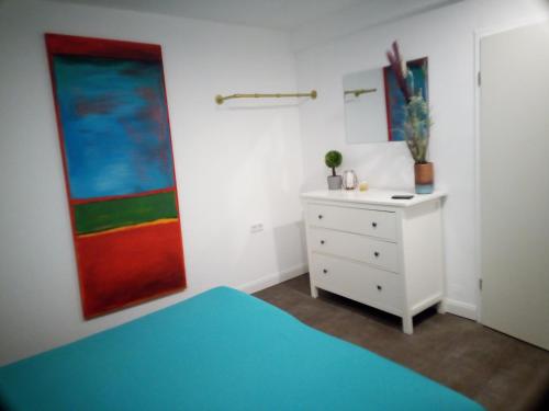 ein Schlafzimmer mit einem Bett und einem Wandgemälde in der Unterkunft Helle und gemütliche 2 Zimmer Ferienwohnung in Ludwigsburg