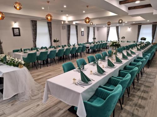 una fila di tavoli e sedie in una stanza con sedie verdi di Hotel Divanhana a Brčko