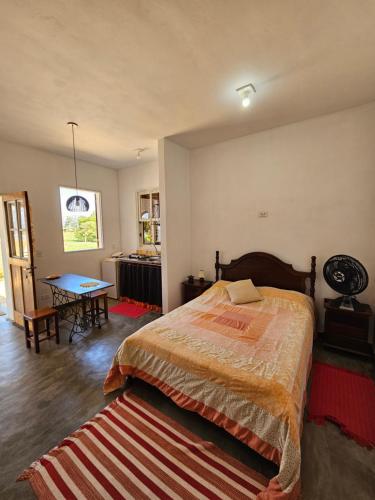 a bedroom with a bed and a table in it at Chalé Arcos do Sol - Carrancas in Carrancas
