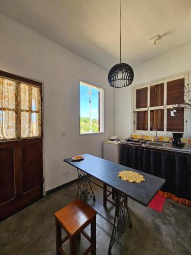 een keuken met een tafel in het midden van een kamer bij Chalé Arcos do Sol - Carrancas in Carrancas