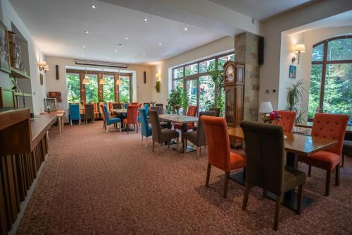 - une salle à manger avec des tables, des chaises et des fenêtres dans l'établissement Opus Villa, à Sinaia