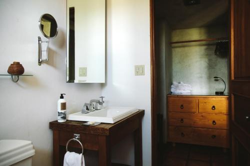 a bathroom with a sink and a wooden dresser at La Villa del Valle in Valle de Guadalupe
