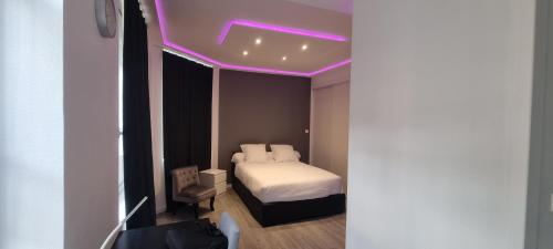 - une chambre avec un lit à éclairage violet dans l'établissement Appartement RGB, à Rouen