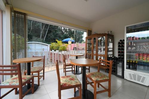 a restaurant with tables and chairs and a window at Pousada Casa Doce Vida in Águas de Lindóia