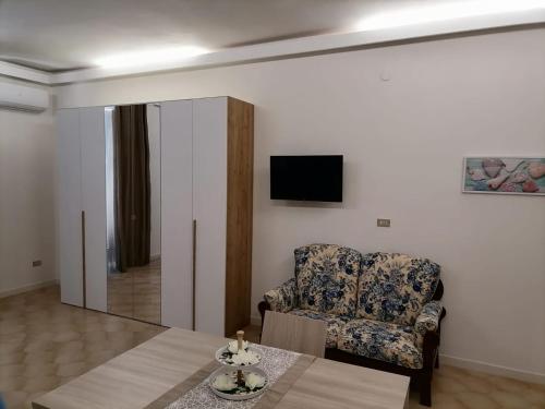 ein Wohnzimmer mit einem Stuhl und einem Tisch in der Unterkunft Casa dell’Assunta in Trani