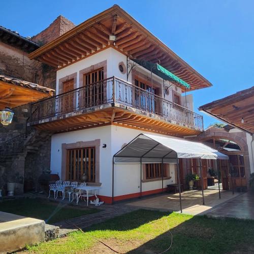 a building with a balcony and a table and chairs at La Casa Baez in Pátzcuaro
