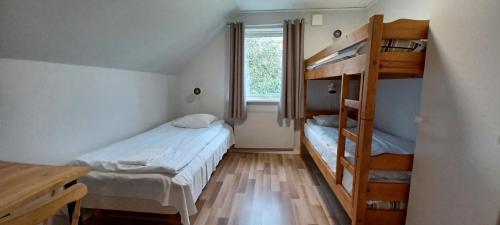 メルビストランドにあるMellbystrand Vandrarhem & Stugor Solstickanの二段ベッド2台、デスクが備わる小さな客室です。
