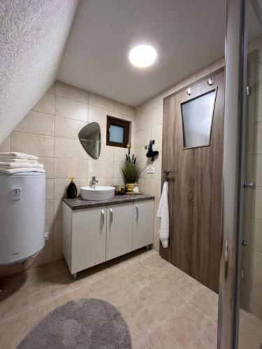 a bathroom with a sink and a mirror at Căsuțele de sub pădure in Avrig