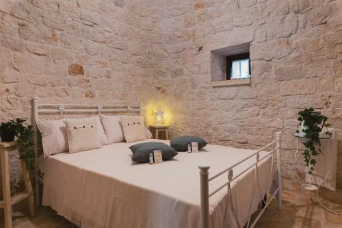 een slaapkamer met een bed in een stenen muur bij Trulli Country House Carla Secret in Castellana Grotte