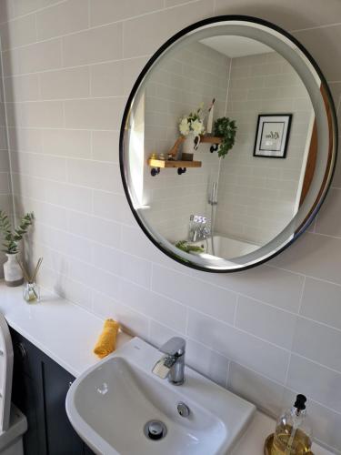 a bathroom with a sink and a mirror at Ornum Self Catering Cottage in Eabost