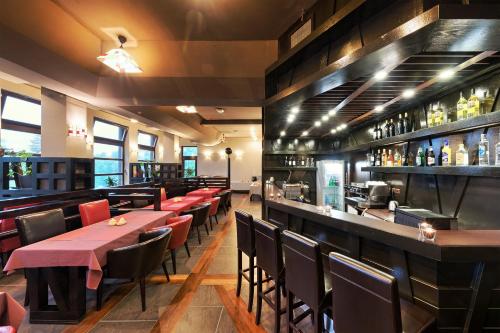 a restaurant with tables and chairs and a bar at Boutique Hotel Sudetia - Medical & SPA in Świeradów-Zdrój