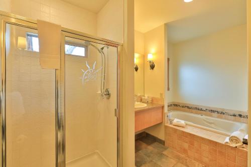 a bathroom with a shower and a tub and a sink at Landhaus Erika in Leavenworth