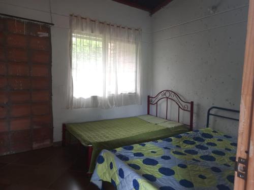 a small bedroom with a bed and a window at Quiero finquear in Manizales