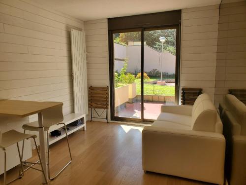 a living room with a white couch and a table at Studio hyper centre in Luchon