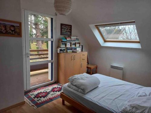 une chambre avec un lit et une fenêtre dans l'établissement Maison de vacances 4 chambres 140 m2 à 1,5 km de la mer, à Pleumeur-Bodou