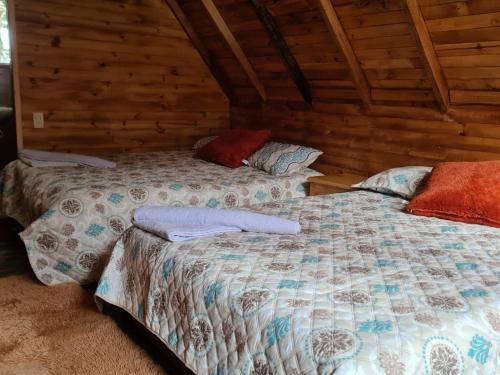 1 dormitorio con 2 camas en una cabaña de madera en Cabañas del bosque en Choachí