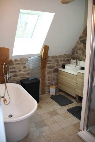 une salle de bain avec une baignoire et un lavabo dans l'établissement Location maison Bourboule, à Murat-le-Quaire