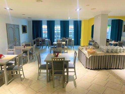 a dining room with tables and chairs and windows at Hotel Jabłoński in Dorotowo