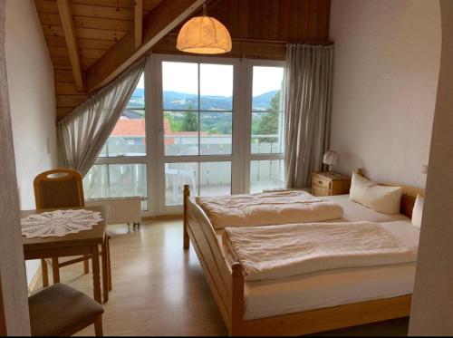 a bedroom with two beds and a large window at Landhaus Schneeberg in Mosbach