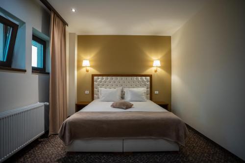 a bedroom with a large bed with two lamps at Opus Villa in Sinaia
