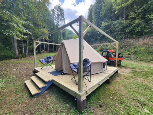 a tent with two chairs on a wooden deck at Glamping tent in Butler