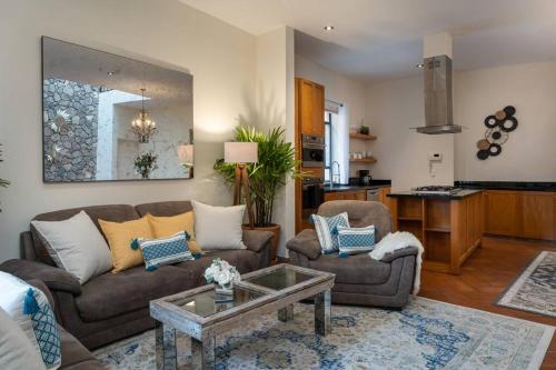uma sala de estar com dois sofás e uma mesa em Elegant 3BR Home with Rooftop & Grill in Centro San Miguel em San Miguel de Allende