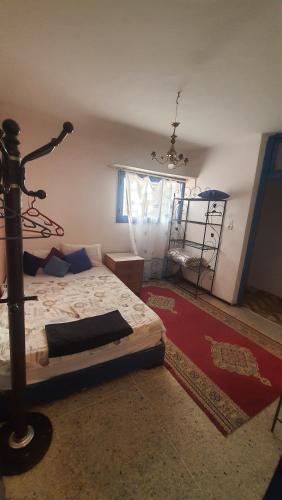 a bedroom with a bed with a rug and a window at Riad Khira in Agadir