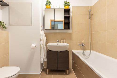 a bathroom with a sink and a tub and a toilet at BNB Slovakia Slnečnice Apartment 1 in Bratislava