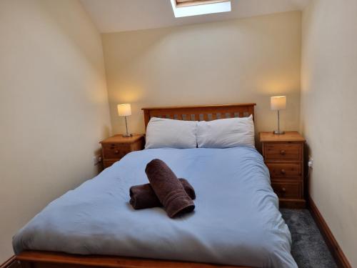 a bedroom with a bed with a stuffed animal on it at Peregrine Stable Cottage in Llandovery