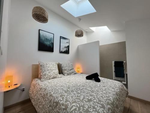 een slaapkamer met een bed en twee lampen aan de muur bij La Terrasse étoilée in Montbrison