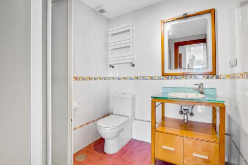 y baño con aseo, lavabo y espejo. en Apartamento Alameda de Colon, en Málaga