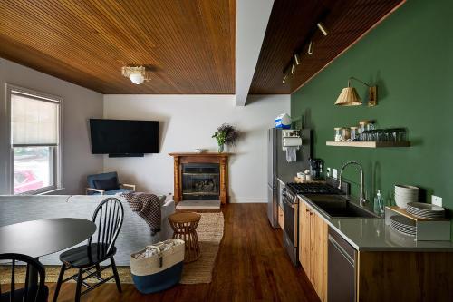 a kitchen with green walls and a table and a fireplace at The Neighborhood Hotel Grand Beach in New Buffalo