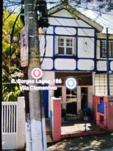 a blue and white house with a street sign on a pole at Casa da Vila Hostel Guest House in Sao Paulo