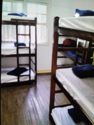 a room with three bunk beds in a room at Casa da Vila Hostel Guest House in São Paulo