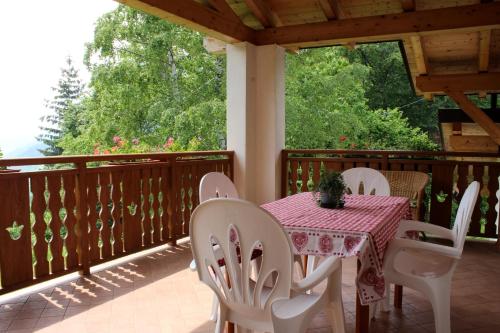 een tafel en stoelen op het terras van een huis bij Appartamento vacanze Riccardo ed Ester in Ronzo Chienis